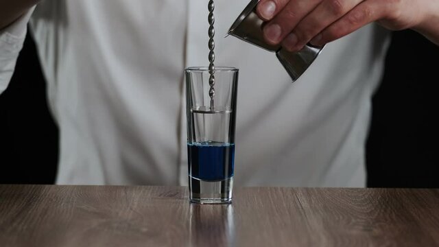 Preparing of Lexus Cocktail. Close up pouring coffee liquor into a glass