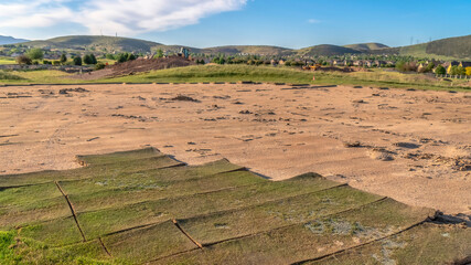 Panorama Vast terrain with grasses against hills and blue sky with clouds background