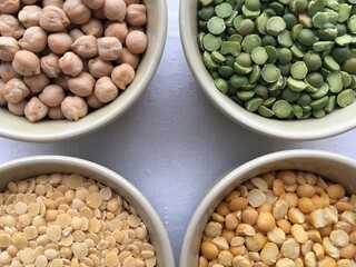 Round bowls with different legumes, peas, chickpeas and lentils on a white linen tablecloth. background for decoration and design of the kitchen, dining room, shop, restaurant
