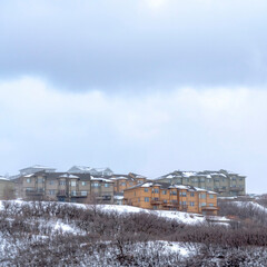 Fototapeta na wymiar Square Hill with homes on its gentle slope covered with fresh snow during winter season
