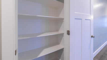 Panorama Empty white wooden shelves in a cupboard