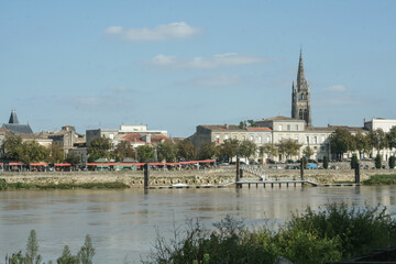 Fototapeta na wymiar Panorama of Libourne seen from the Garonne river with a focus on the church of Eglise Saint Jean Baptiste. Libourne is a major town in Gironde, in the Aquitaine region
