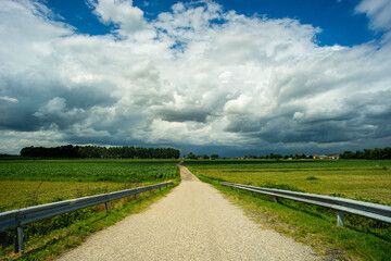 Fototapeta na wymiar country dirt road that meets the storm