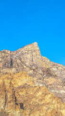 Fototapeta na wymiar Vertical crop Steep peak and rocky slopes of a mountain in Provo Canyon Utah on a sunny day