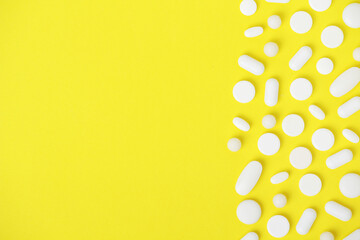 Bright yellow background with white medicine tablets
