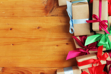 Fototapeta na wymiar Gifts packed with craft paper and colorful satin ribbons
