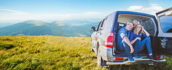 Family sitting in car trunk while journey to mountains © oksix