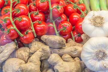 Delicious fresh market vegetables tomatoes ginger and garlic. Offer mix box of ripe organic vegetable for balanced nutrition recipe. Seasonal gourmet cooking ingredients for healthy quality meal