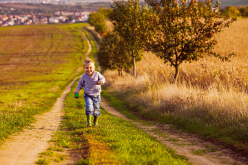 The inspired little boy having fun walking on country road