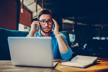 Stressed businessman receiving call from bank about paying bill for debt