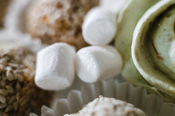 Fototapeta na wymiar a bunch of cakes in sesame, meringue and marshmallows