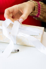 woman ties a ribbon on a gift