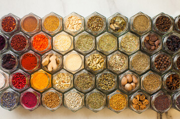 Assorted spices pattern top view in hexagon bottles in the kitchen