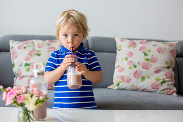 Happy school boy drinking a healthy smoothie