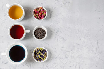 Obraz na płótnie Canvas Three cups of tea, from dried rosebuds, thai butterfly pea tea, black tea.