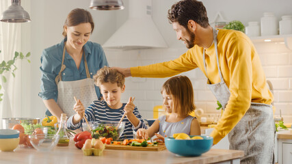 In Kitchen: Family of Four Cooking Together Healthy Dinner. Mother, Father, Little Boy and Girl,...