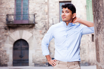 Fototapeta na wymiar young European guy in blue shirt walking around city