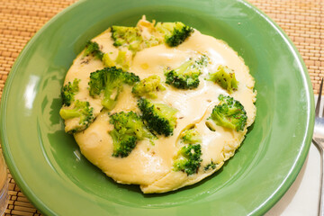 wholesome breakfast. omelet with broccoli on green plate