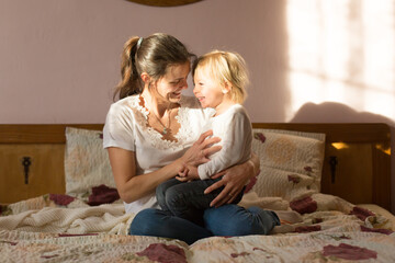 Mom and child, having fun together, reading book and eating croissant