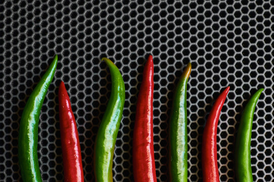 green and red hot chili peppers on a dark background close up the top vertically