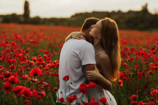 Loving couple in the poppy field. 
The guy gently kisses his girlfriend in the neck. Loving couple hug one another during romantic date in poppy field. Enjoying time together. Passion.