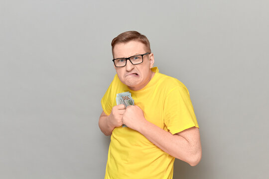 Portrait of funny greedy man holding money in hands
