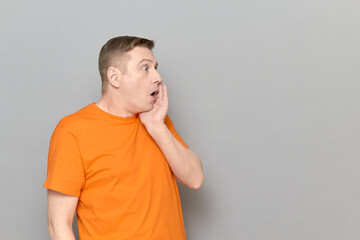 Portrait of shocked man touching cheek with one hand and screaming