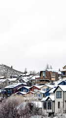 Vertical crop Houses on residential hill in Park City Utah with snow dusted slopes in winter