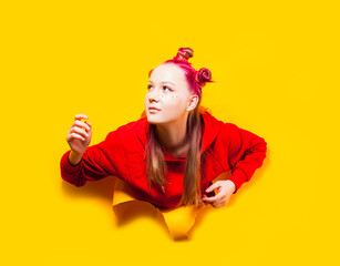 Girl actively getting out of hole in paper wall