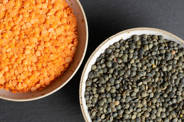 Red and green lentils in ceramic bowl on a slate background