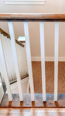 Fototapeta na wymiar Vertical frame U shaped stairway of home with brwon handrail supported by white balusters