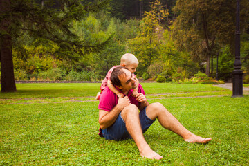 Dad and son together on the grass in park