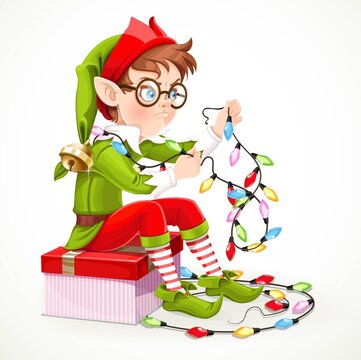 Cute boy elf sitting on a box with a gift and unravels a Christmas garland isolated on white background