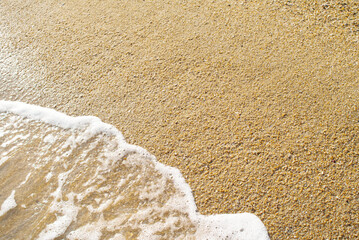 Beach sands with white foam waves approaching in tropical summer background with copy space for text