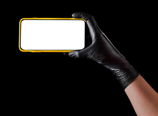 Hand in black glove holding mobile phone with blank screen isolated on black