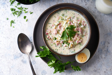 Traditional Russian cold okroshka soup served in a plate with herbs Kefir vegetable soup