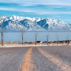 Square crop Snowy Wasatch Mountains and blue Utah Lake with road in the foreground