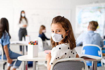 Child with face mask back at school after covid-19 quarantine and lockdown.