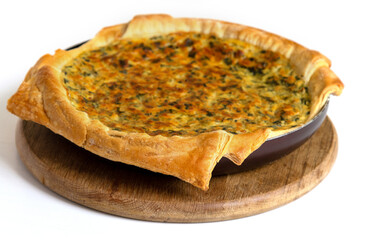 Pie with cheese and onions for lunch, on a white table.