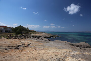 panorama landscape scenic view of isolated deserted rocky beach with blue turquoise sea water and sky with white clouds background on beautiful and colorful Mallorca island in Spain