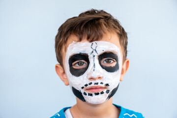 Arabic boy had a skull being draw on his face for halloween