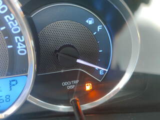 Naklejka premium Fuel gauge showing empty tank with yellow glowing and lit meter