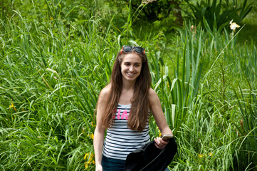 picnic. happy girl with long hair in sunglasses hold smartphone. smiling woman among green grass reeds. summer weekend. holiday and vacation. human and nature. outdoor relax. spring happiness