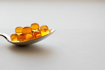 Omega 3 Capsules with fish oil in a spoon