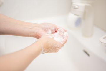 清潔な洗面所で石鹸で手を洗う人