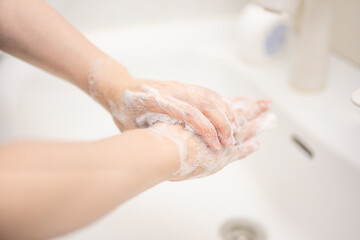 Obraz na płótnie Canvas 清潔な洗面所で石鹸で手を洗う人
