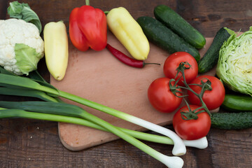On the table are cabbage, onion peppers, cucumbers and tomatoes.