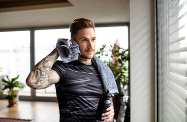 Portrait of man resting after workout exercise indoors at home.