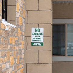 Square Exterior view of apartments with No Smoking sign on the stone brick wall