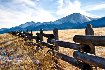 A ranch fence in Colorado with a mountain background. - obrazy, fototapety, plakaty